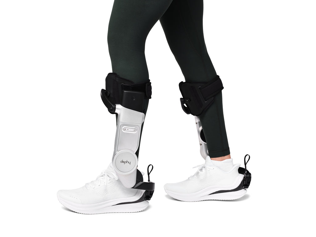 Person wearing black ankle braces on a white background