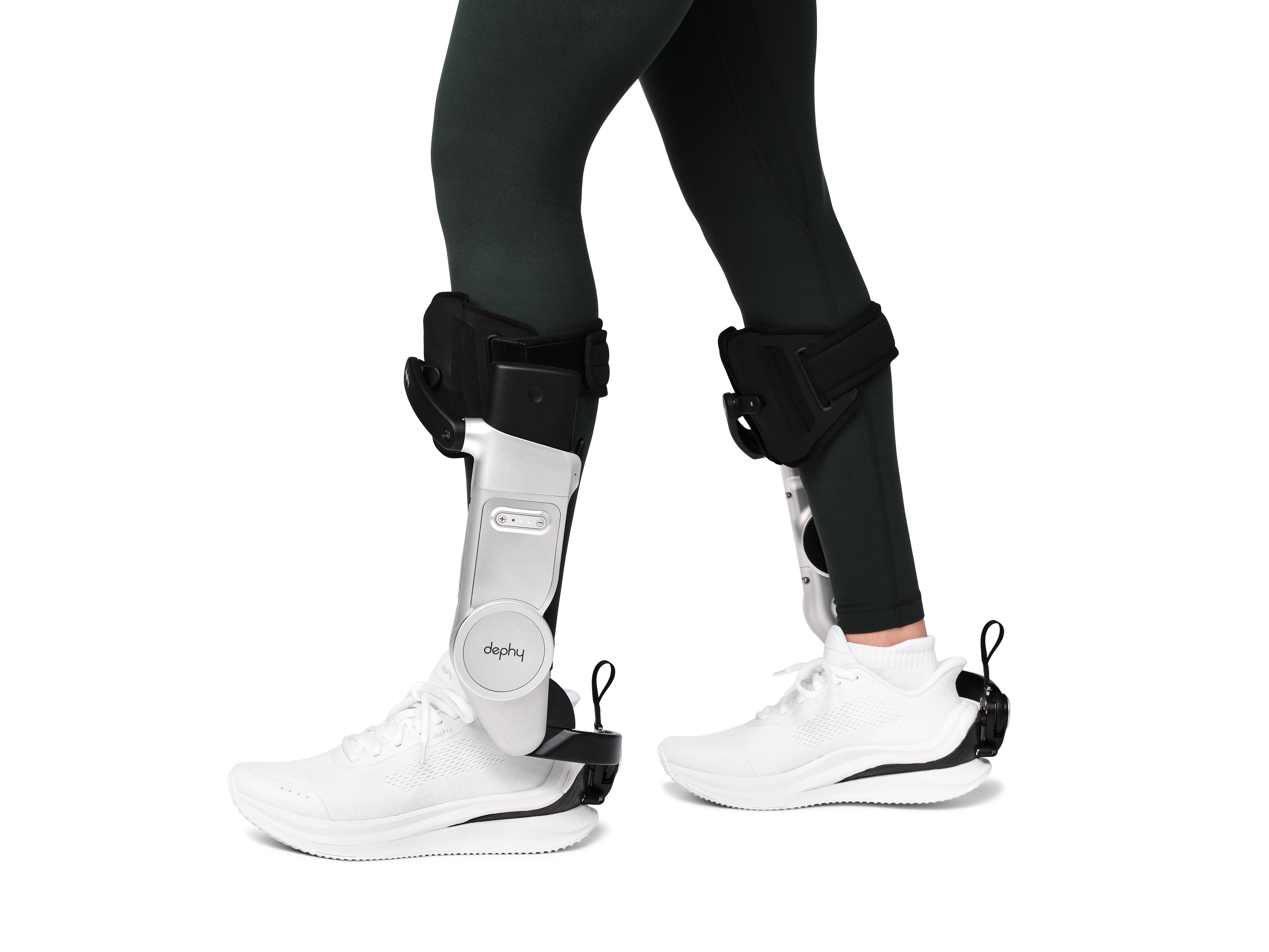 Person wearing black ankle braces on a white background